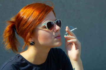 Obraz premium girl smokes a cigarette, and holds a cigarette in her hand