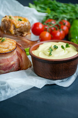 Baked young potatoes with cheese, bacon. Dark background. Close-up.