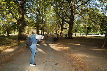 Mujer mirando un mapa en parque de Londres.