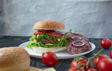 Fresh homemade burger. Fresh vegetables, herbs and beef cutlets for cooking a burger. American cuisine.