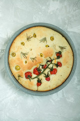 Traditional italian focaccia with tomatoes, olives and rosemary. Baked focaccia in a baking sheet. Italian Cuisine . Space for text.