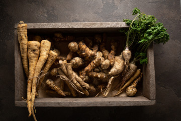 Fresh jerusalem artichoke roots and parsnip roots in crate