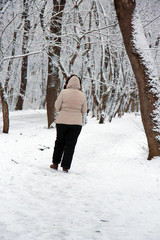 Woman walking alone in the winter park outdoor