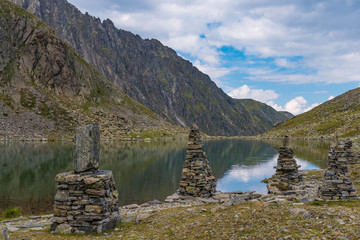 Fototapeta na wymiar cairns at the shore of a lake in the mountains