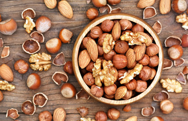 Colorful mix of nut and seed varieties: peanut, cashew, hazelnut, almond, pine nuts, walnut, pumpkin seeds; healthy diet snack; vegan food background	