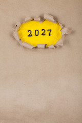 The concept of the New Year with the number 2027 placed in a leaky paper on crumpled yellow paper