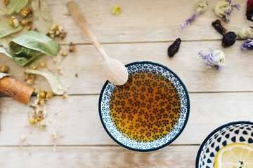 Autumn hot herbal tea with honey, cinnamon and lemon. Top view. Image toned.