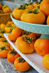 Fototapeta na wymiar Basket of freshly picked orange persimmon kaki fruits
