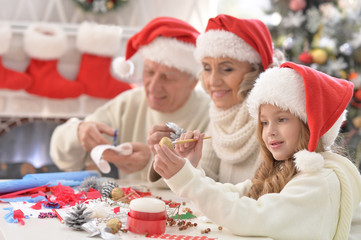 Happy grandparents with grandchild preparing for Christmas together