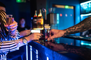Girl holding margarita cocktail on the table in the restaurant. Alcoholic drinks.