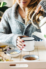 Pouring tea into a cup. Autumn hot herbal tea with honey, cinnamon and lemon. Top view. Image toned.