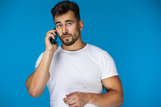 Handsome man speaks by phone and seems lost