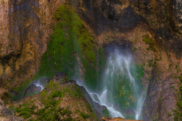 Fototapeta na wymiar Close detail of Pisoaia waterfall streaming down through the moss in Apuseni Mountains, Transylvania, Romania