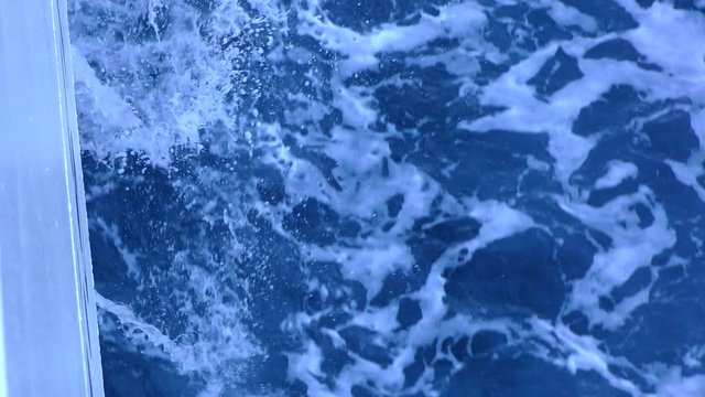 Bright blue sea water foaming around the board a seagoing ship. Sea ferry goes along the Ionian Sea.