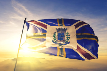 Governador Valadares of Brazil flag waving on the top sunrise mist fog