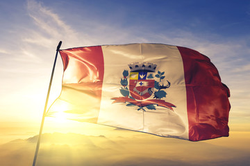 Marilia of Brazil flag waving on the top sunrise mist fog