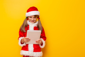 Child in Santa costume using tablet