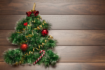 Wooden background with Christmas toys in red, decorated with garlands and shiny balls. The concept of Christmas or New year.
