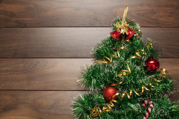 Wooden background with Christmas toys in red, decorated with garlands and shiny balls. The concept of Christmas or New year.