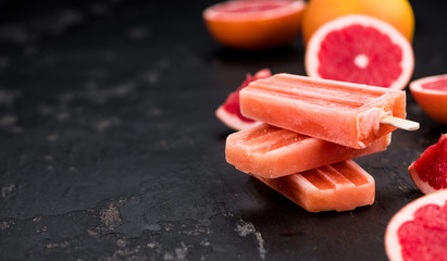 Slate slab with fresh Grapefruit Popsicles (selective focus)