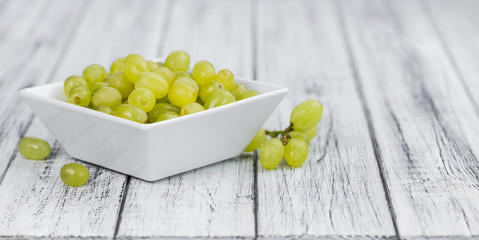 Wooden table with White Grapes (detailed close-up shot; selective focus)