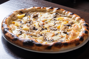 Cheap pizza with mushrooms, pineapple, and corn.