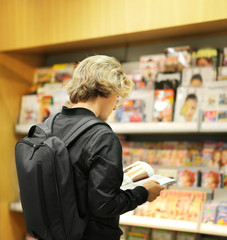 man buying a magazin in a store