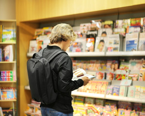 man buying a magazin in a store