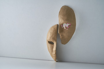 Composition with half of the paper masks on a light gray background with a delicate bouquet of...