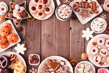 Christmas table scene of mixed sweets and cookies. Above view over a rustic wood background....