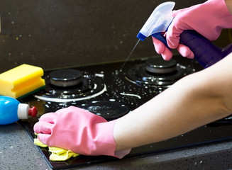 Cleaning a gas stove with kitchen utensils, household concepts, or hygiene and cleaning.
