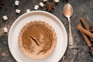 Yellow pumpkin pie orange  pumpkins with yelllow dry autumn leaves decor on dark table background.Harvesting,autumn and Thanksgiving concept