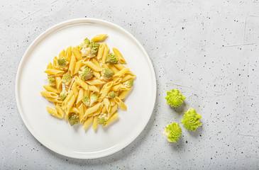 Penne pasta with romanesco cabbage on light gray background
