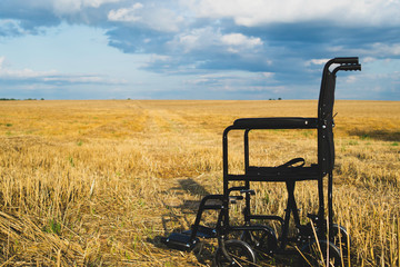 Empty wheelchair in a wide meadow. disabled carriage in nature. medical equipment for invalid person