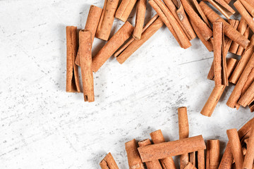 Cinnamon bark sticks on white stone like board, overhead photo