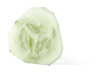 Cucumber slice, with skin peeled, isolated on white background