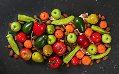Mixed vegetables and fruit on black marble like board, view from above