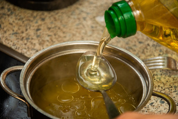 Oil pouring and dripping to the spoon