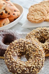 Sweet delicious dessert. Donut with a hole and with chocolate coating and nuts.
