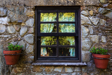 Fototapeta na wymiar Window with curtains and vases in stone house