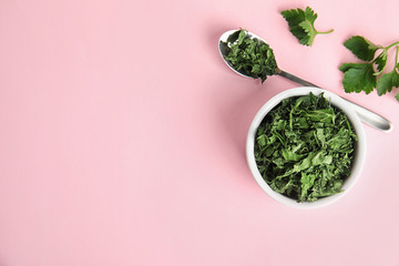 Flat lay composition with fresh and dried parsley on pink background. Space for text
