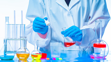 The technician mixes the chemical liquid. Addition of reagents. Chemical reaction. Demonstration of...