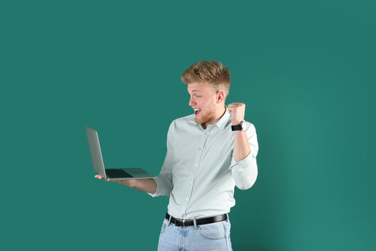 Emotional Man With Laptop On Green Background