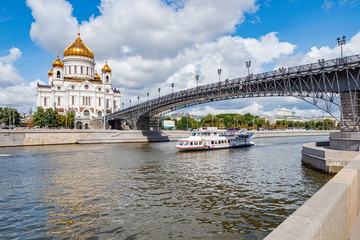 Fototapeta na wymiar Moscow on a summer day. Cathedral Of Christ The Saviour. Ship on the river Moscow. Boat trips on the river Moscow. Patriarch bridge. The bridge leads to the temple. Summer trip to Russia.