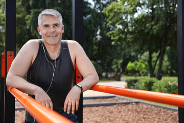 Handsome mature man having rest after exercise on sports ground, space for text. Healthy lifestyle © New Africa