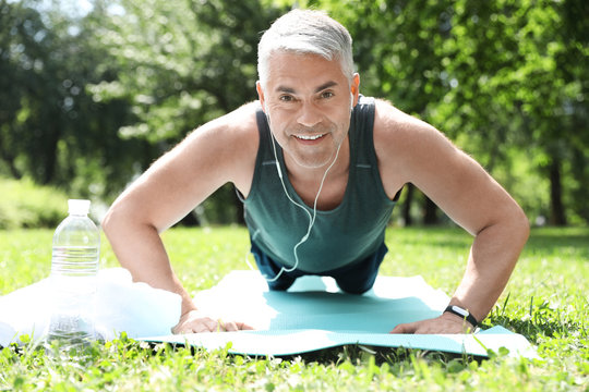 Handsome mature man doing exercise in park. Healthy lifestyle