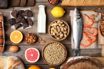 Flat lay composition of different products on wooden table. Food allergy concept