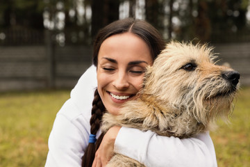 Female volunteer with homeless dog at animal shelter outdoors