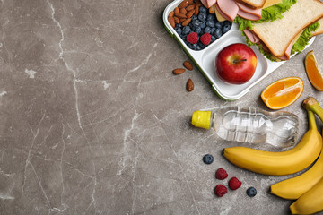 Flat lay composition with healthy food and space for text on grey table. School lunch