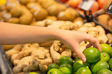 Female hand choosing lemon in the market